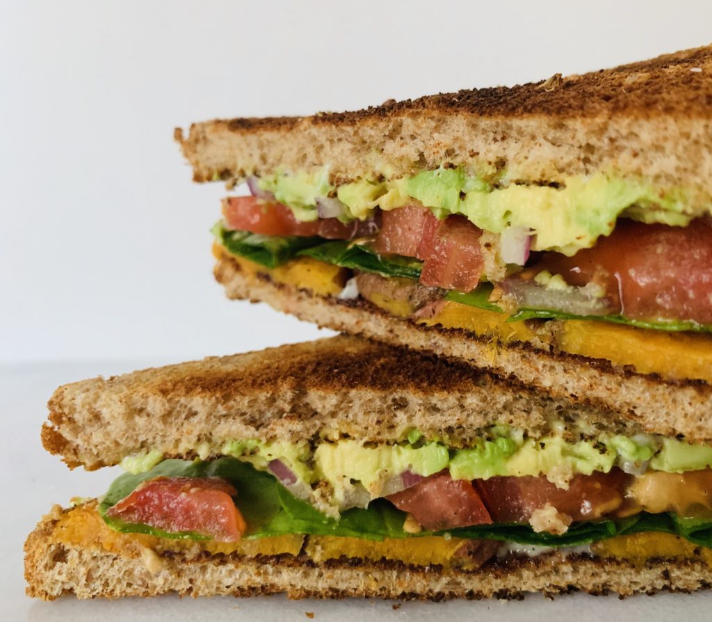 Constructed SPLAT sandwich with sweet potatoes, lettuce, avocado and tomato on toasted bread.